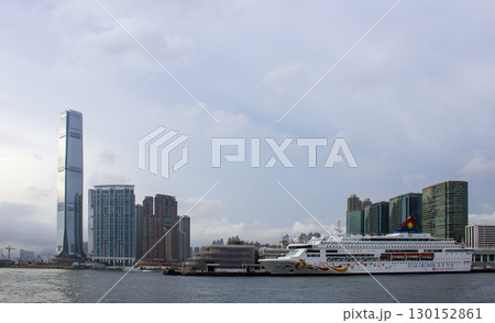 View Of Skyscrapers And Apartment Buildings With Cruise Ship Docked At Tsim Sha Tsui Harbour, Hong Kong. 130152861