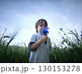 Beautiful little boy in flowers. A cute child in nature with flowers in her hands 130153278