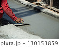 Workers are leveling the floor after pouring concrete. 130153859