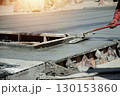 Workers are leveling the floor after pouring concrete. 130153860