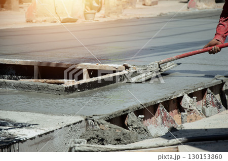 Workers are leveling the floor after pouring concrete. Workers are leveling the floor after pouring concrete. 130153860