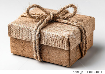 Kraft paper with a twine bow. Minimalist brown Kraft Gift Box with twine bow on white background. 130154031