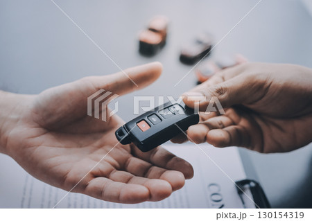 Car salesman gave the keys to the customers who signed the purchase contract legally, Successful completion of car sales, Purchase contract and key delivery. 130154319