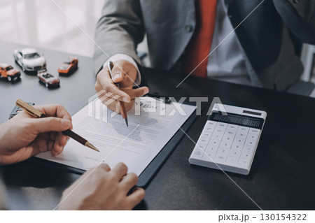 Car salesman gave the keys to the customers who signed the purchase contract legally, Successful completion of car sales, Purchase contract and key delivery. 130154322