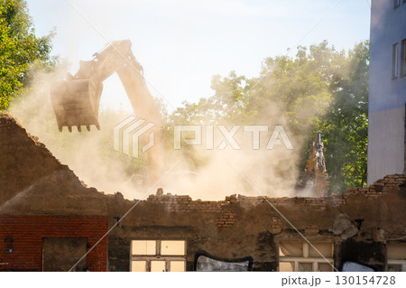 Excavator demolishing an old building on a city street. Concept of urban redevelopment, structural dismantling and transformation of city architecture 130154728