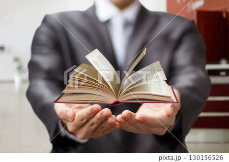 Presenting knowledge with a book in a professional setting. 130156526