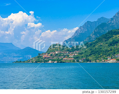 View of Iseo Lake Surrounded by Majestic Mountains and Clear Blue Skies, Italy View of Iseo Lake Surrounded by Majestic Mountains and Clear Blue Skies, Italy 130157299
