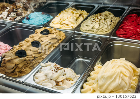 Bright assortment of gelato in multiple flavors including licorice, pistachio, vanilla, and berry in a display freezer. Artisanal desserts, gelato, flavor experimentation, local sweet traditions Bright assortment of gelato in multiple flavors including licorice, pistachio, vanilla, and berry in a display freezer. Artisanal desserts, gelato, flavor experimentation, local sweet traditions 130157622