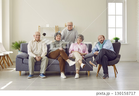 Group of elderly people, mature friends sitting on couch at home Group of elderly people, mature friends sitting on couch at home 130158717