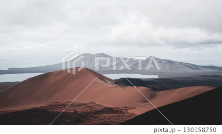 Breathtaking volcanic landscape at sunset with distant mountains and a calm lake 130158750