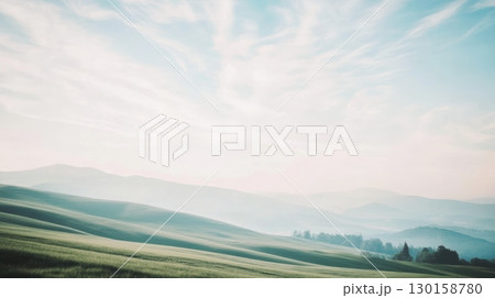 Scenic landscape view of rolling hills under a serene sky at dawn 130158780