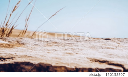 Natural rock formation under a clear sky with dry grass in the background during midday sun 130158807