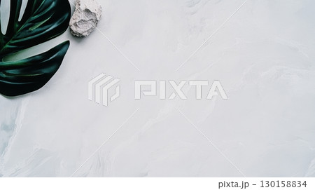 Elegant arrangement of tropical leaves and natural stones on a minimalist surface 130158834