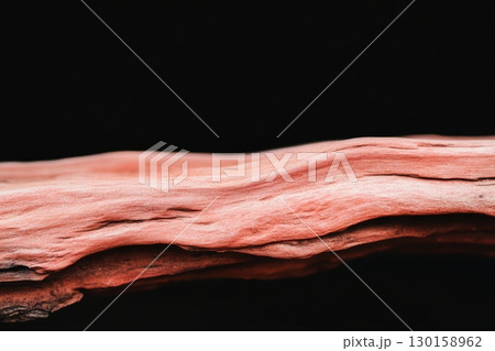 Wood texture showcasing natural patterns and colors illuminated against a black background 130158962