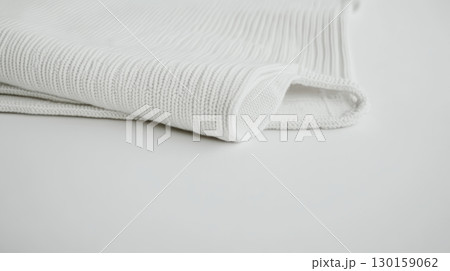 Soft white fabric neatly folded on a smooth surface in a well-lit room 130159062