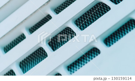 Unique close-up of modern air vent design showcasing intricate patterns and textures in bright light Unique close-up of modern air vent design showcasing intricate patterns and textures in bright light 130159114
