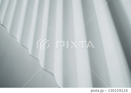 Elegant white fabric cascading in soft folds creates a serene and minimalist atmosphere in a tranquil setting 130159128