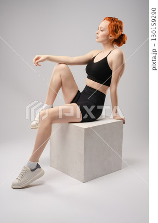 Woman showcasing beauty in stylish athletic wear while posing with light effects 130159290