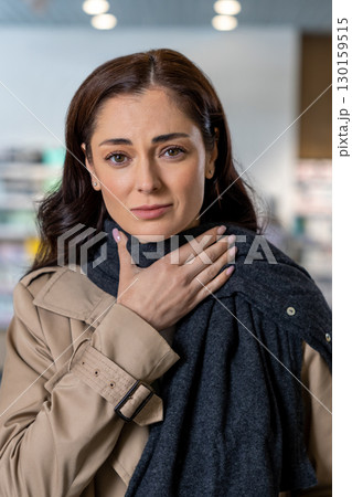 Dark-haired young woman having a sore throat and suffering from pain Dark-haired young woman having a sore throat and suffering from pain 130159515