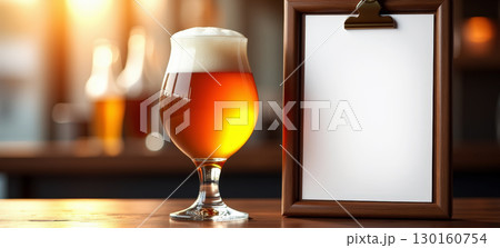 Beer with a glass and a menu on the bar counter 130160754