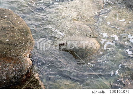 Rocky shoreline with clear water and gentle waves at the coast Rocky shoreline with clear water and gentle waves at the coast 130161075