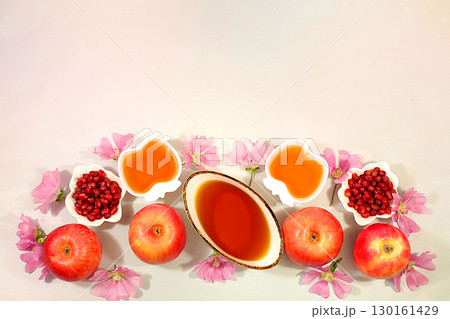 Creative composition for the Jewish holiday Ro Hashanah with a place for congratulations. Layout with traditional symbols of the Jewish New Year, template with honey, apples, pomegranate and flowers 130161429