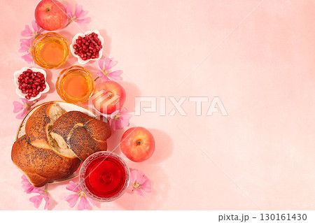 Jewish holiday Rosh Hashanah concept with apples, honey, pomegranate, flowers, red wine and Challah bread for greeting card, creative mockup and template for Jewish New Year. 130161430