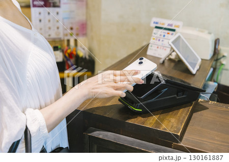 カフェのレジでキャッシュレス決済 をする女性 カフェのレジでキャッシュレス決済 をする女性 130161887