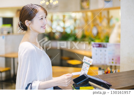 カフェのレジでキャッシュレス決済 をする女性 カフェのレジでキャッシュレス決済 をする女性 130161957