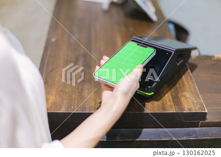 レジでキャッシュレス決済 をする女性 レジでキャッシュレス決済 をする女性 130162025