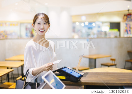 カフェのレジでキャッシュレス決済 をする女性 カフェのレジでキャッシュレス決済 をする女性 130162028