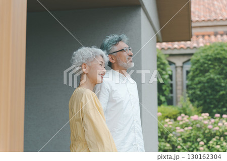 自宅の庭を眺めるシニア夫婦 自宅の庭を眺めるシニア夫婦 130162304