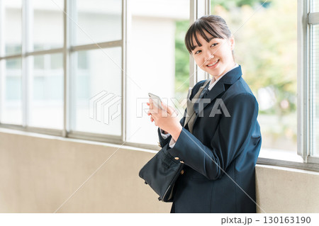 校舎の廊下でスマホを使う笑顔の小学生,中学生,高校生の女の子(防犯,安全,安心) 校舎の廊下でスマホを使う笑顔の小学生,中学生,高校生の女の子(防犯,安全,安心) 130163190