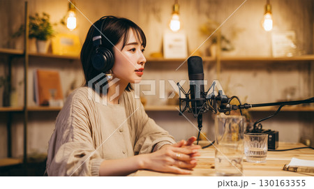 女性がスタジオでポッドキャスト番組を収録する 女性がスタジオでポッドキャスト番組を収録する 130163355