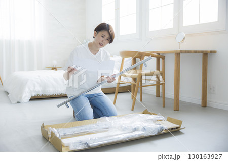 ハンガーラックを組み立てる女性 130163927