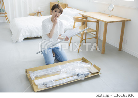 ハンガーラックを組み立てる女性 130163930