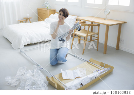 ハンガーラックを組み立てる女性 130163938