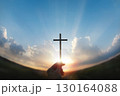 A hand holding the cross of Jesus Christ toward the rising sun, a background of faith, hope, and the New Year. 130164088