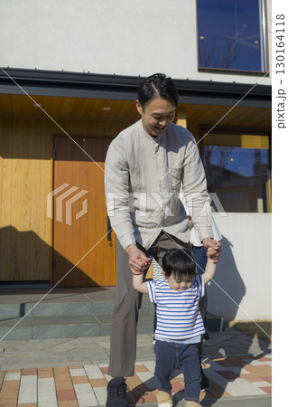 家の前に立つ家族 130164118