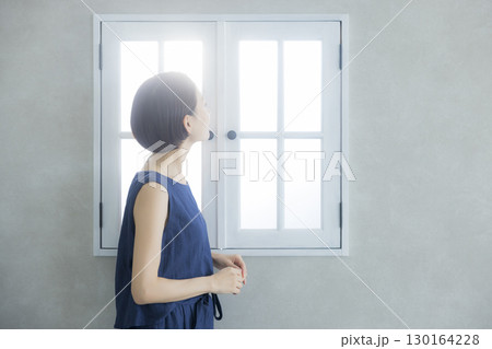 窓際に立つ女性 130164228