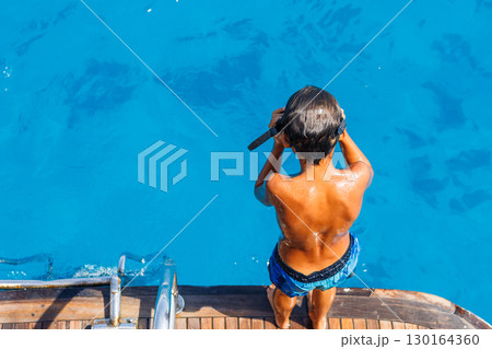 Child preparing to dive into ocean 130164360