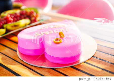 Heart-shaped pink cake with rings on top Heart-shaped pink cake with rings on top 130164365