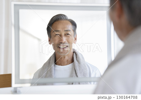 鏡を見て微笑む60代の男性　メンズビューティー・ヘルスケア　イメージ 130164708
