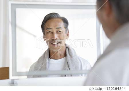 鏡を見て微笑む60代の男性　メンズビューティー・ヘルスケア　イメージ 130164844