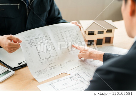 設計図を使い物件の説明をする作業着姿の営業マン,設計士の男性スタッフ 設計図を使い物件の説明をする作業着姿の営業マン,設計士の男性スタッフ 130165581