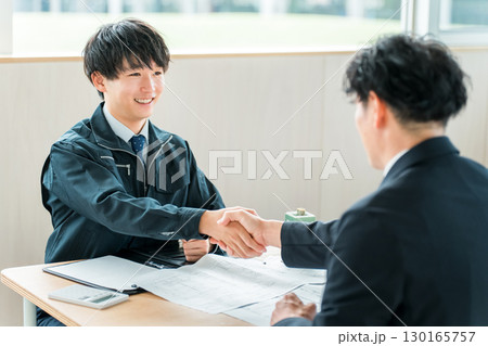 ビル,テナントの契約,商談をする作業着姿の若いアジア人ビジネスマン 130165757