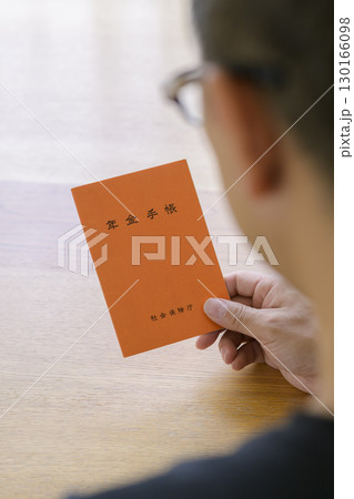 年金手帳を見つめる男性 年金手帳を見つめる男性 130166098