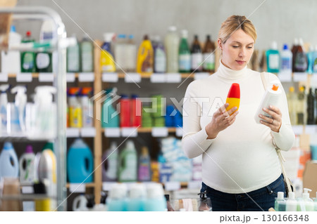 Focused pregnant woman choosing sunscreen in store Focused pregnant woman choosing sunscreen in store 130166348
