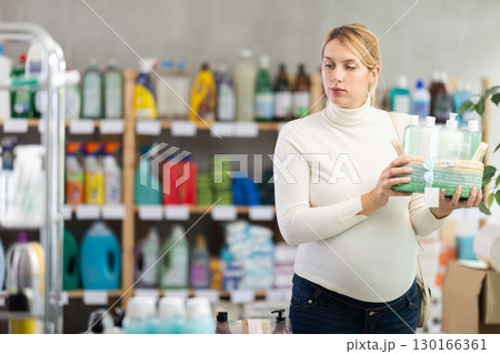 Young expectant mother choosing gift basket with toiletries in store Young expectant mother choosing gift basket with toiletries in store 130166361