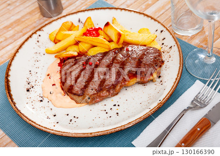 Beef entrecote with potatoes served at plate closeup 130166390